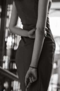 Black and white photo of a model wearing a sleek, modern outfit from cuts, standing against a minimalist urban backdrop.