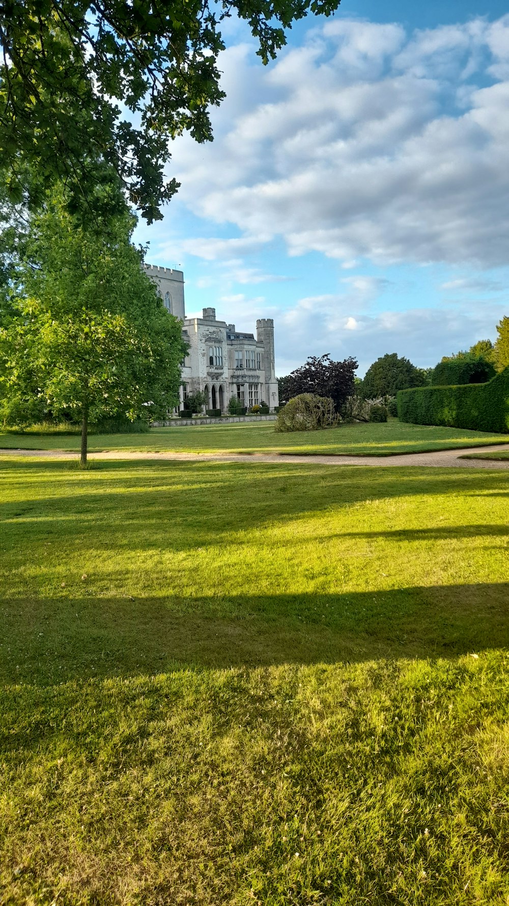 a large white house sitting on top of a lush green field