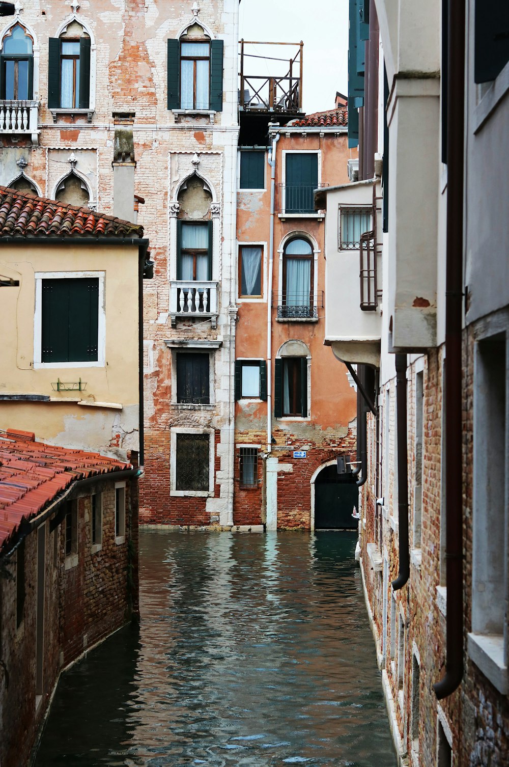 a narrow canal with buildings in the background