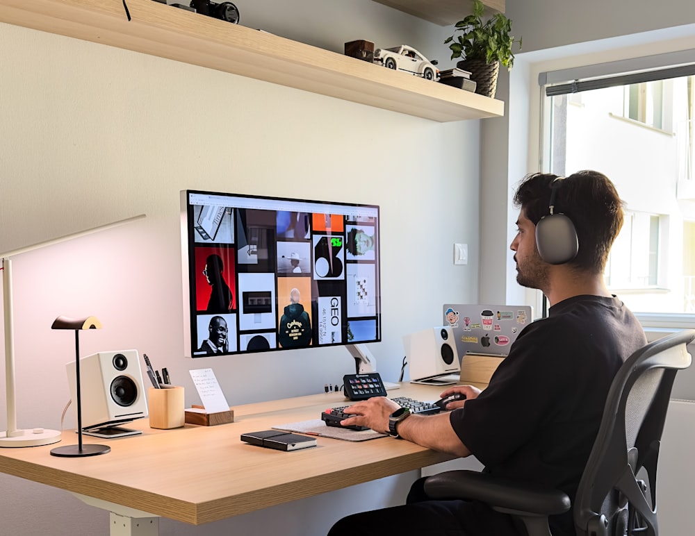 a man sitting at a desk with headphones on