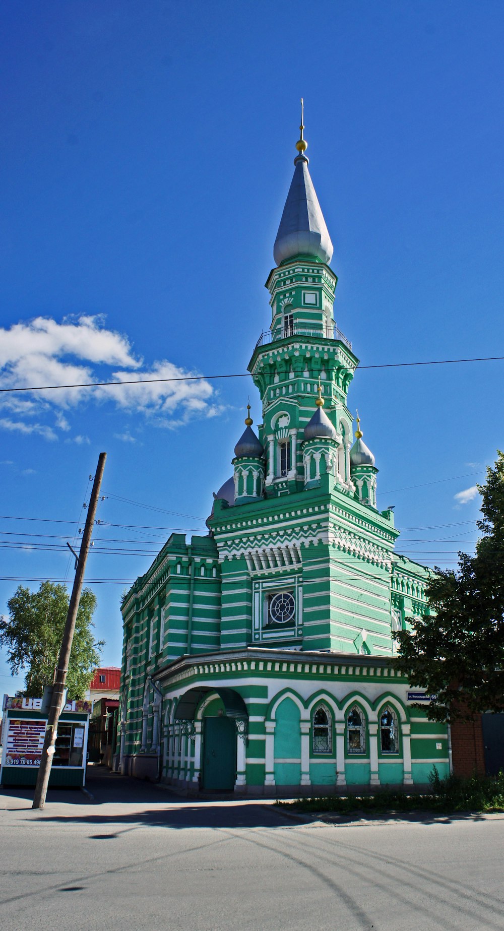 a green and white building with a clock on it