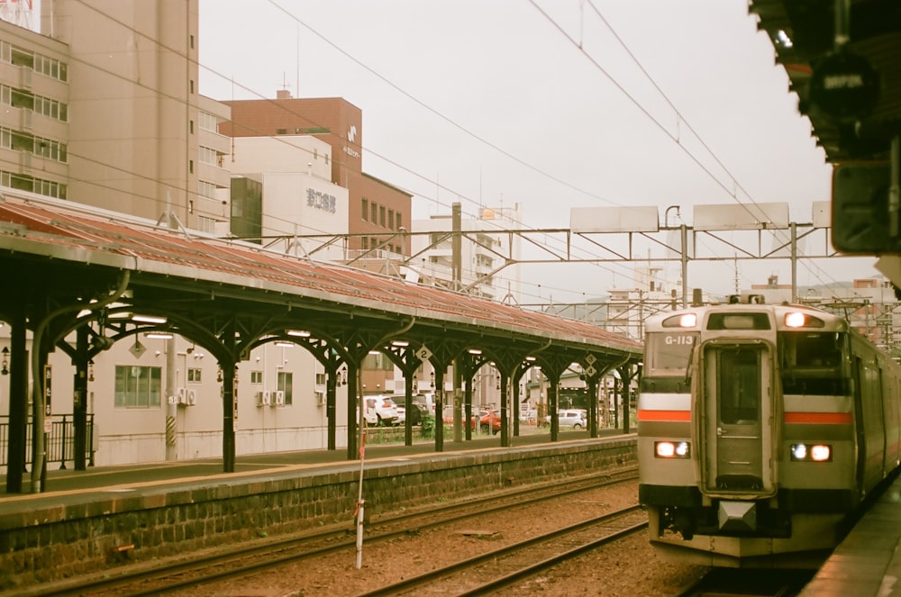 a train traveling down train tracks next to a train station