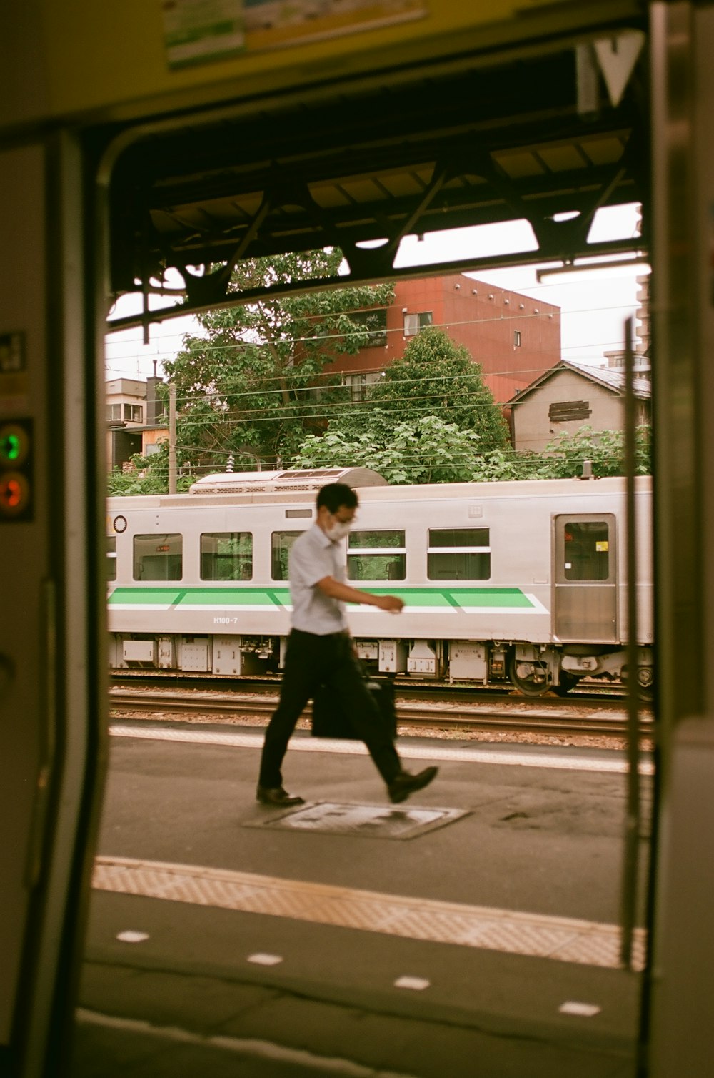 a man walking across a train platform next to a train
