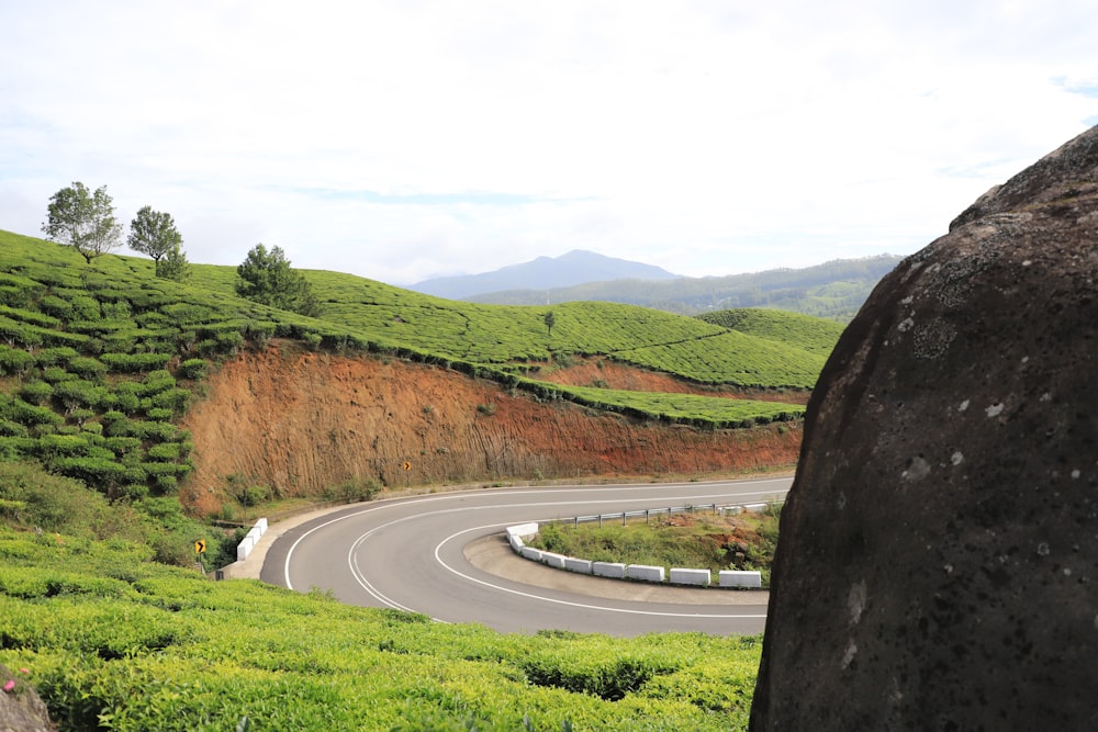 a curved road surrounded by lush green hills