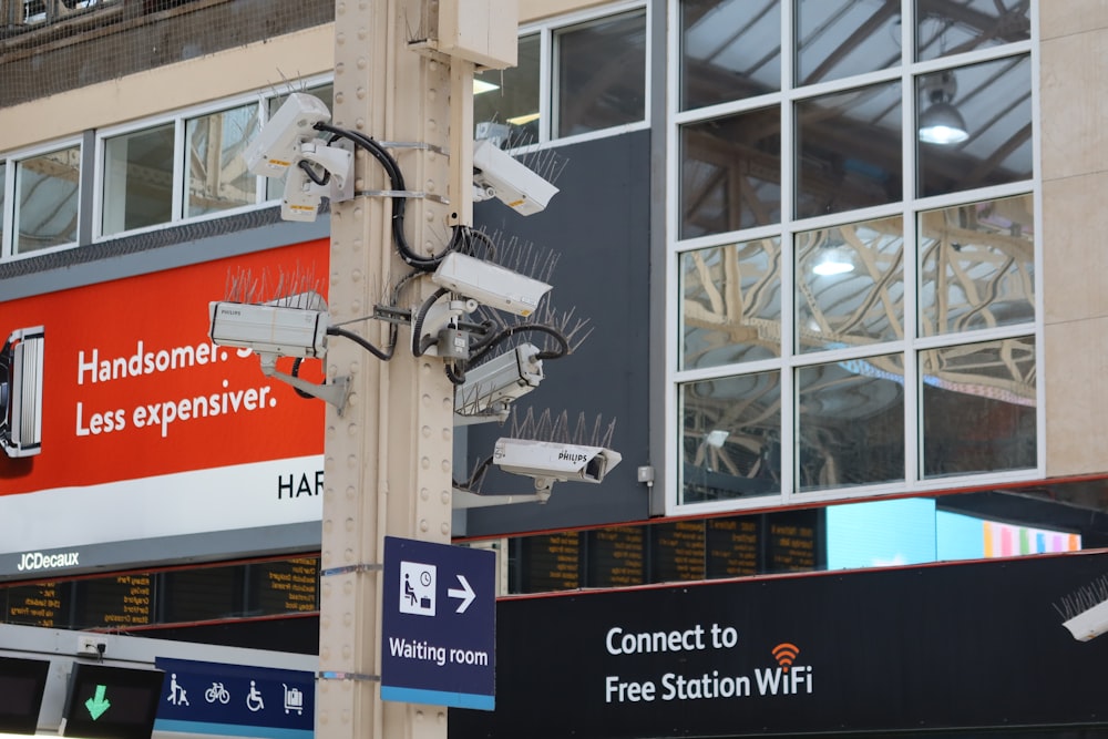 a bunch of cameras on a pole outside of a building