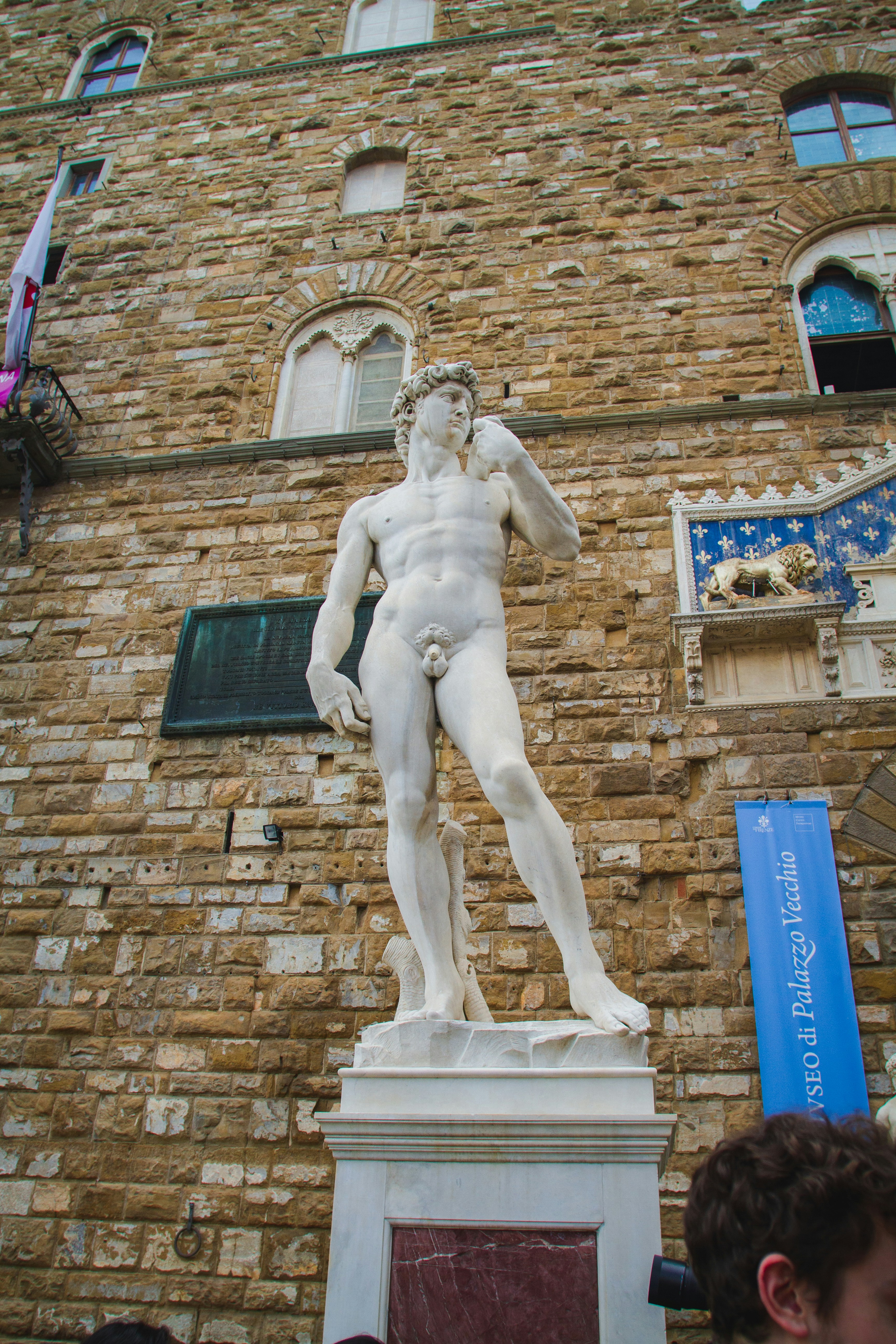 a statue of a man standing in front of a brick building