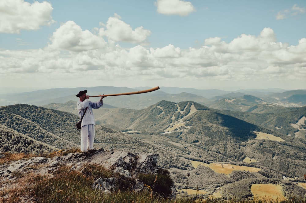 a man holding a baseball bat on top of a mountain