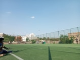 A group of students playing sports on a sunny outdoor school field.