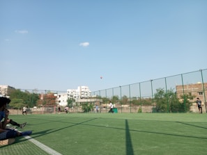 Community members playing soccer together on a sunny field.