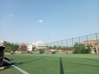 Residents playing a friendly soccer match outdoors on a sunny day.