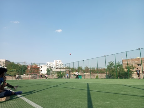 Residents playing a friendly soccer match outdoors on a sunny day.