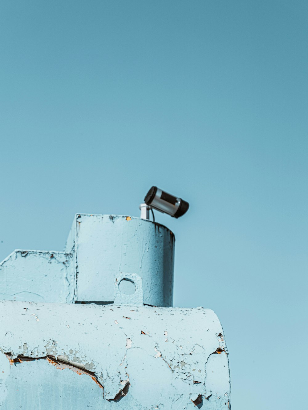 an old rusted metal object with a camera on top of it