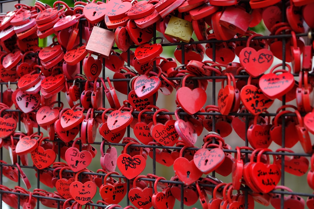 a bunch of red hearts attached to a fence