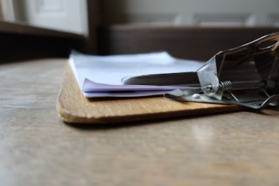 Close-up of a clipboard with a completed job checklist and a pen resting on it.