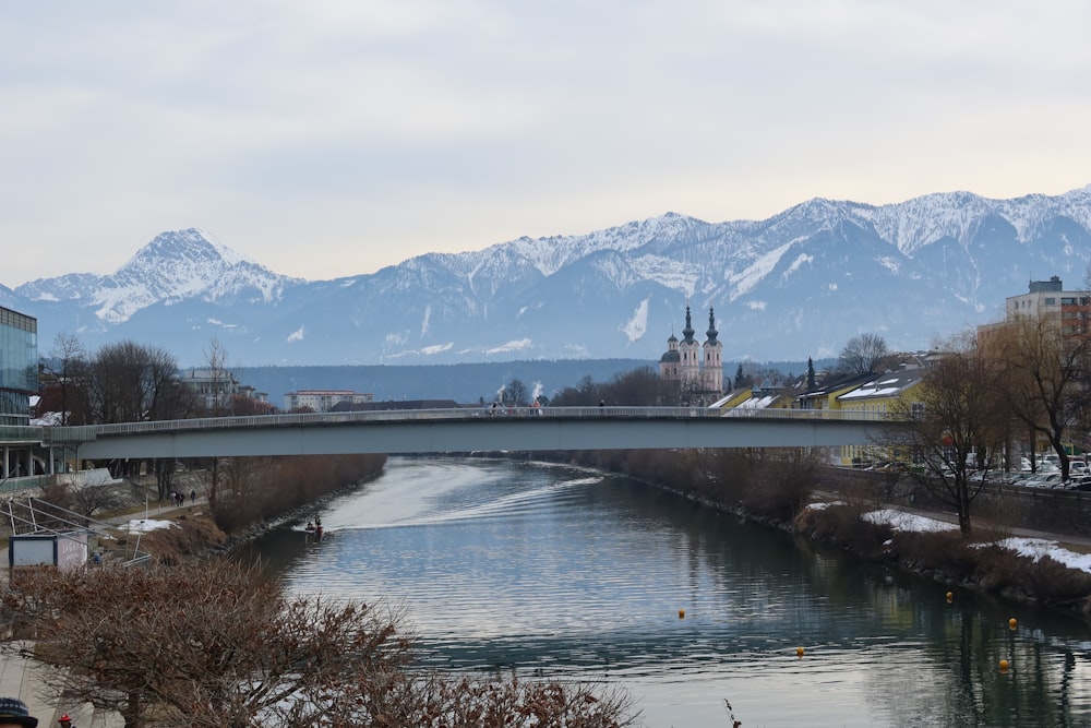 a bridge over a river with mountains in the background