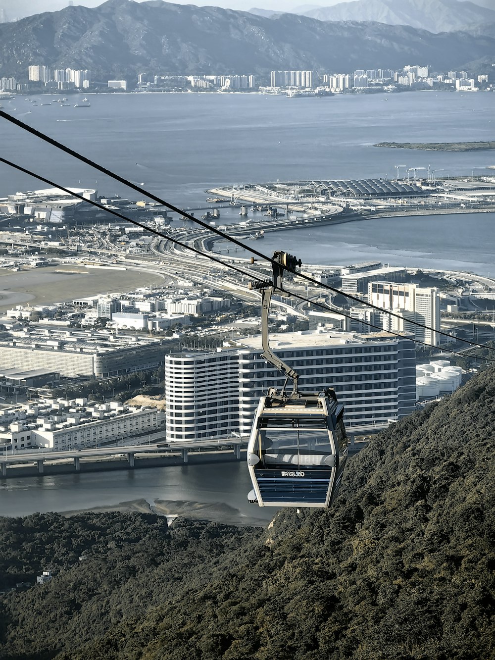 a cable car going up a hill with a city in the background