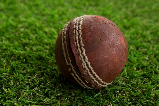a close up of a cricket ball on some grass