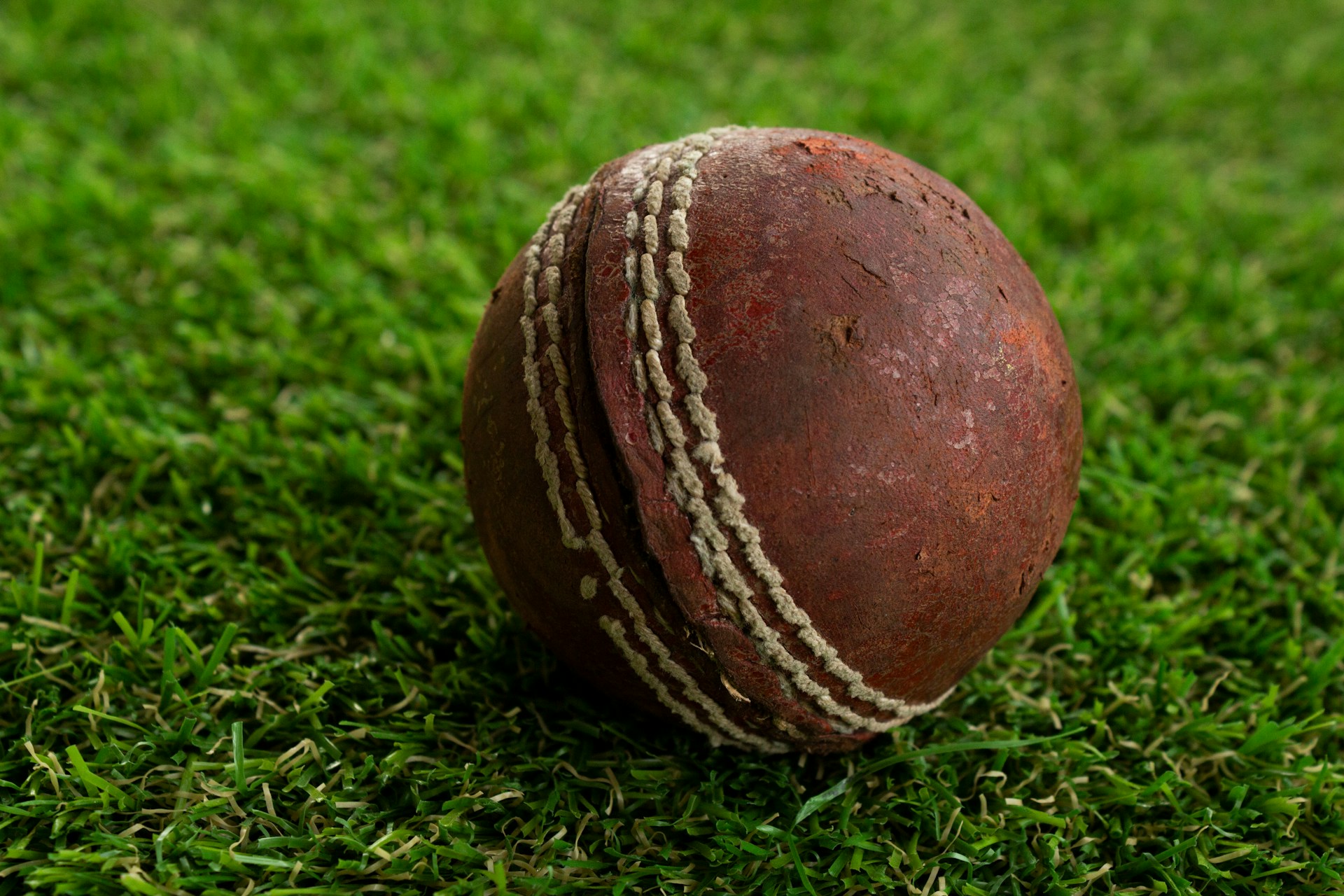 a close up of a cricket ball on some grass
