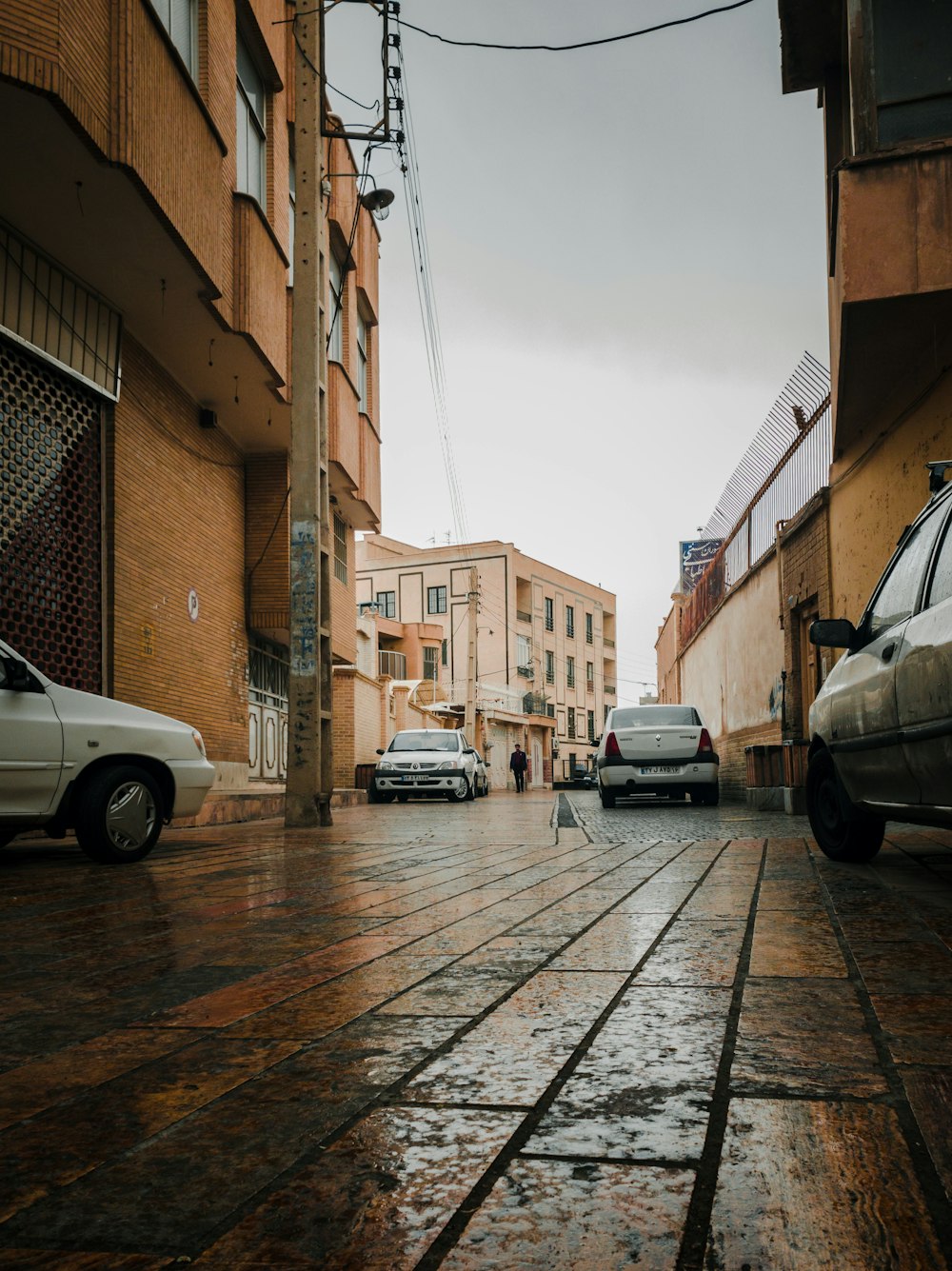 uma rua da cidade com carros estacionados ao lado dela