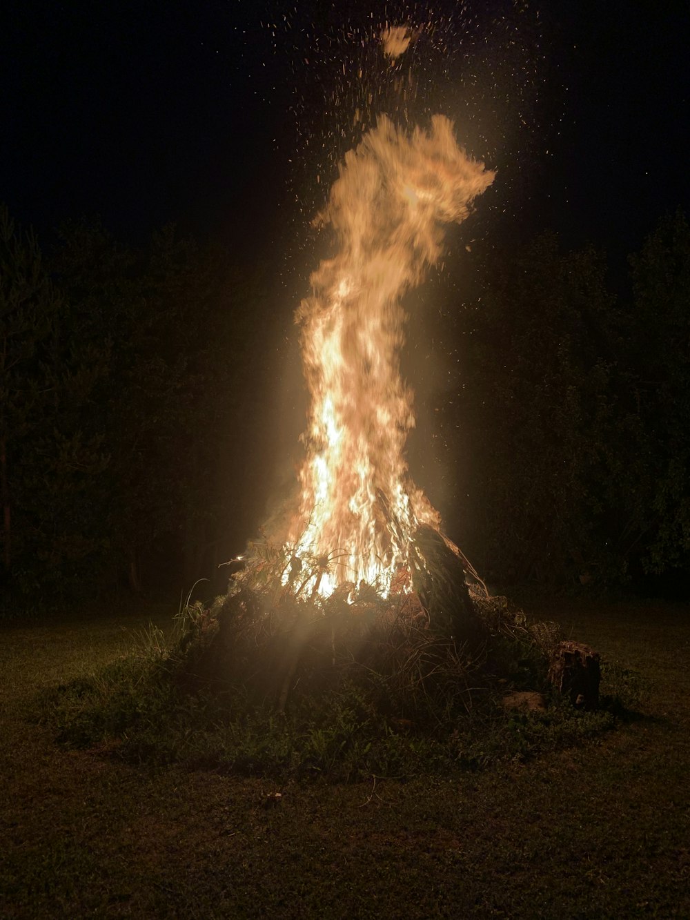 a bonfire is lit in a field at night
