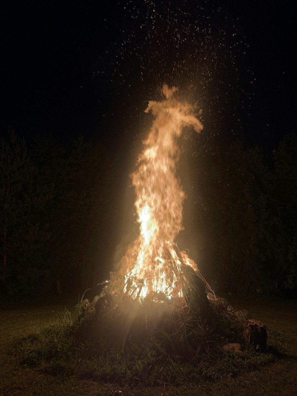 Nachts wird auf einem Feld ein Lagerfeuer entzündet