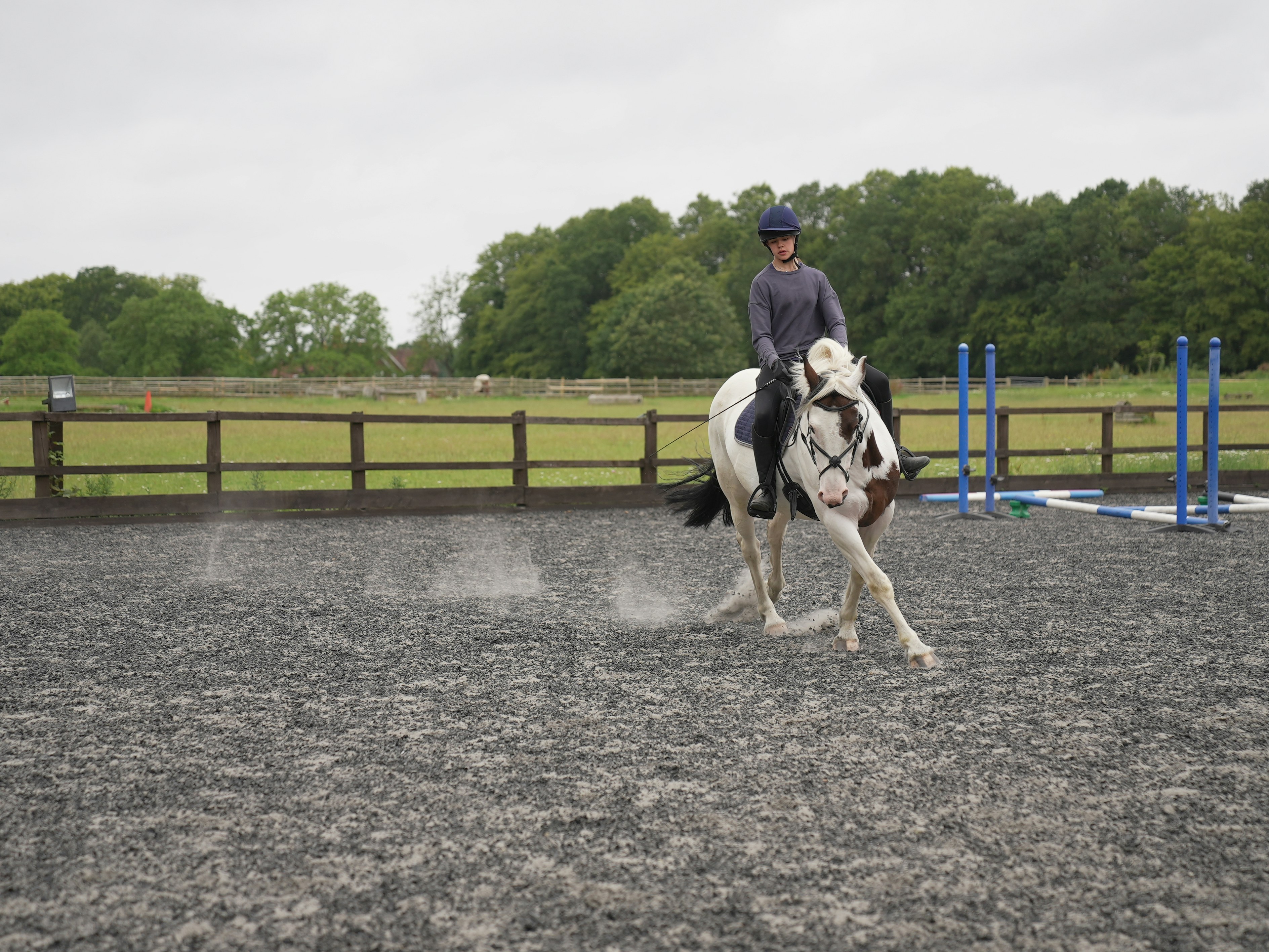 Rider on a paint horse practicing western reining in a dusty arena