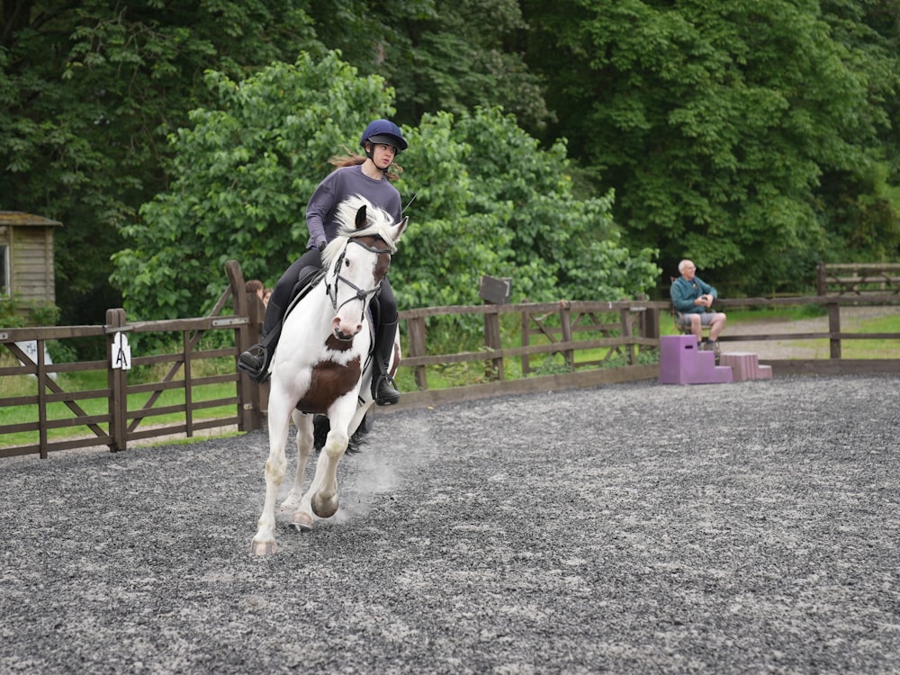 a person riding a horse in a fenced in area