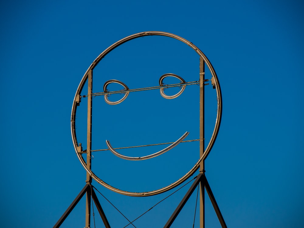 a metal smiley face on top of a building