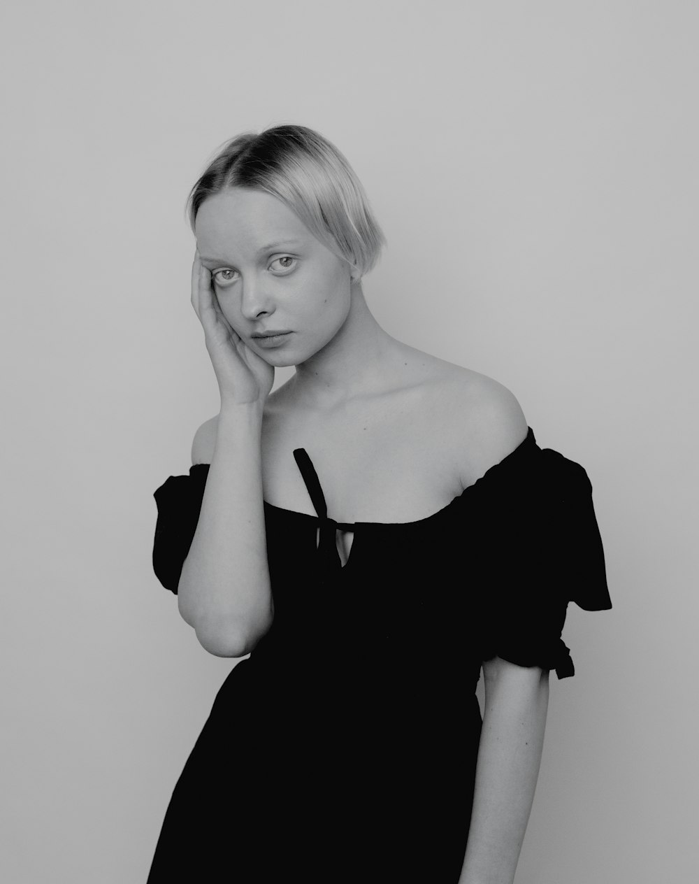 a black and white photo of a woman in a black dress