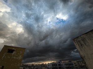 A dramatic weather scene capturing dark clouds over a cityscape.