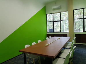 A modern office meeting room with green army and gold accents reflecting professionalism.