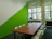 A professional business meeting in a modern office with deep green accents.