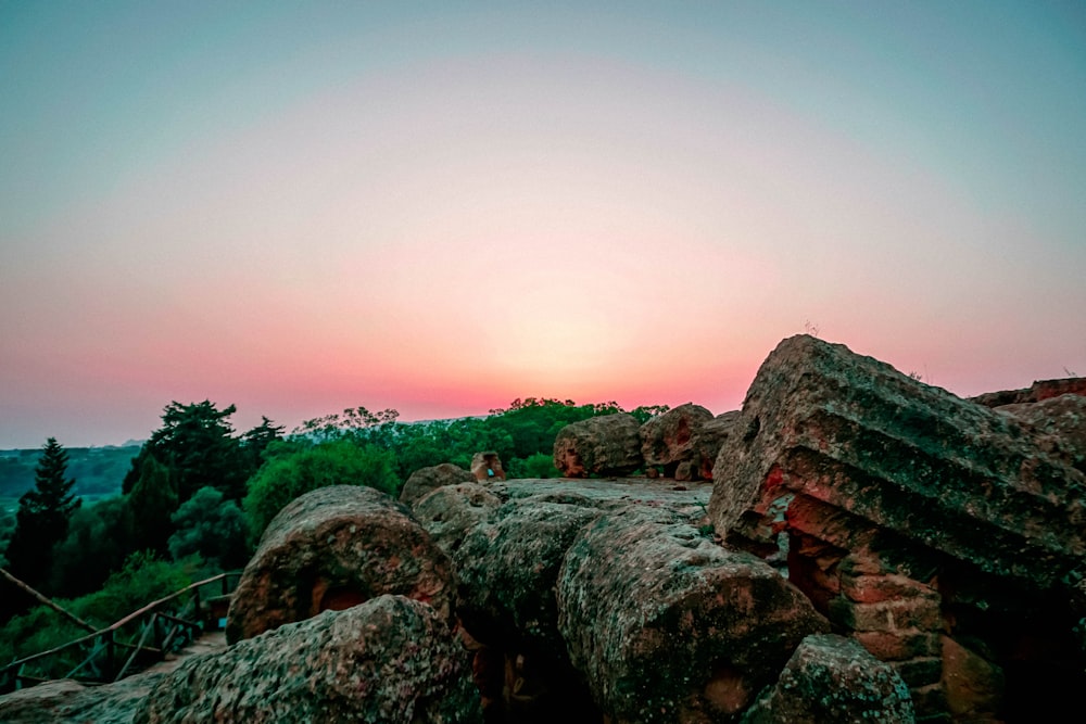 the sun is setting over the rocky terrain