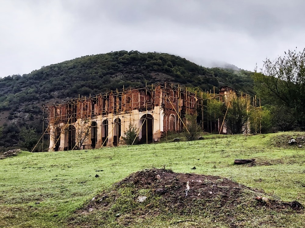 um grande edifício sentado no topo de uma colina verde exuberante