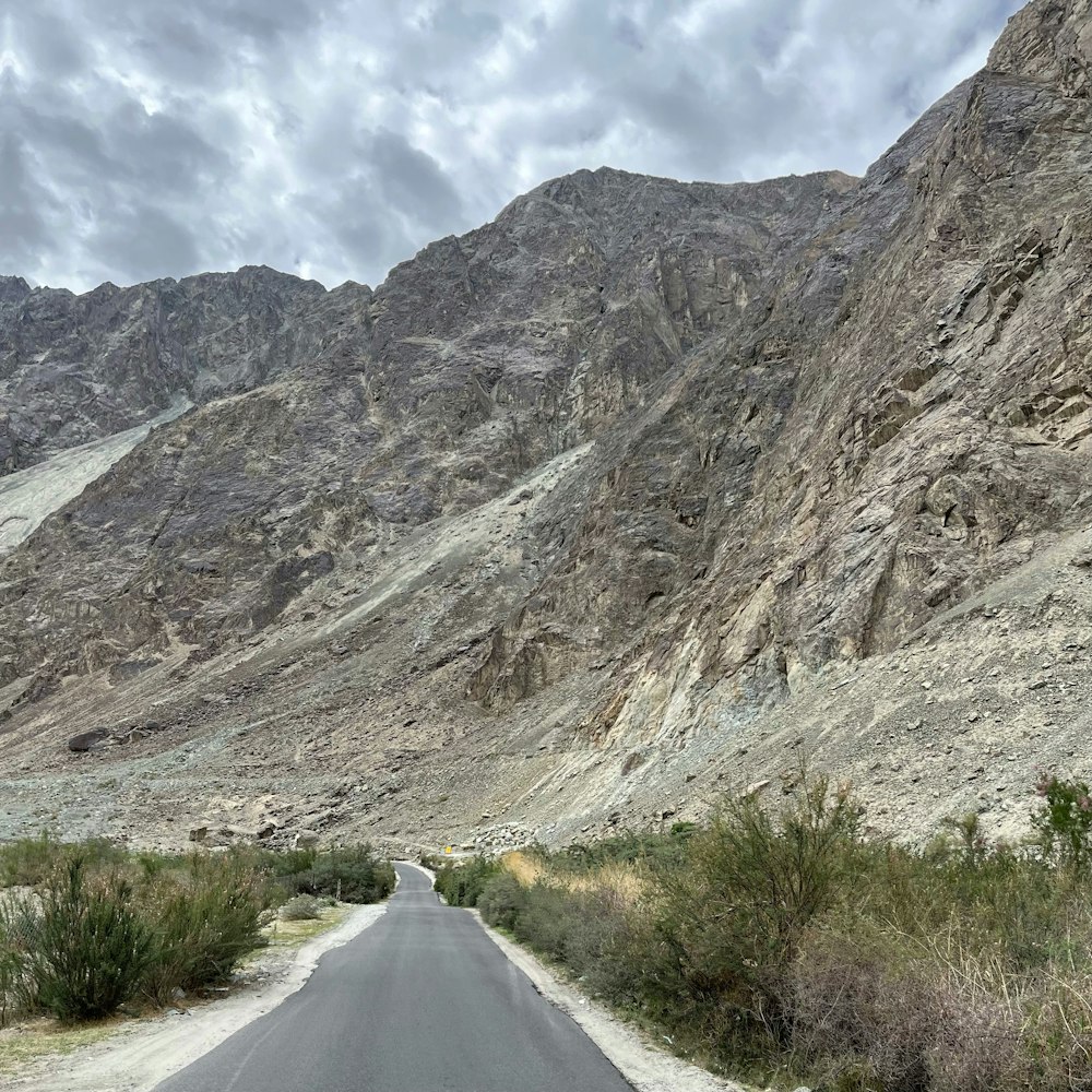 an empty road in the middle of a mountain range