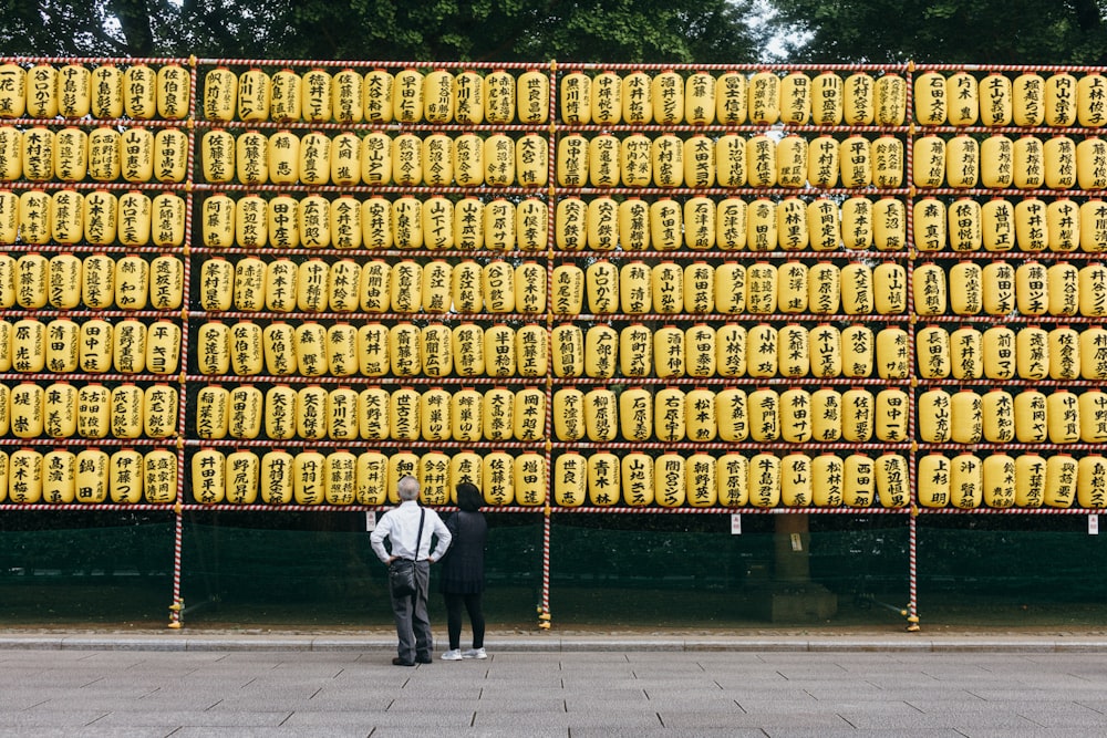 two people standing in front of a large display of bananas