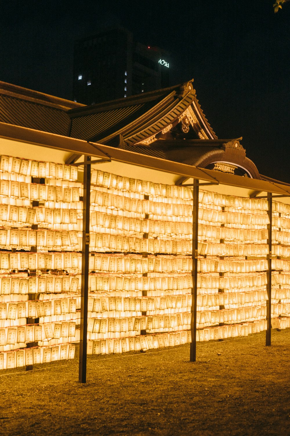 a large wall of lit candles in front of a building