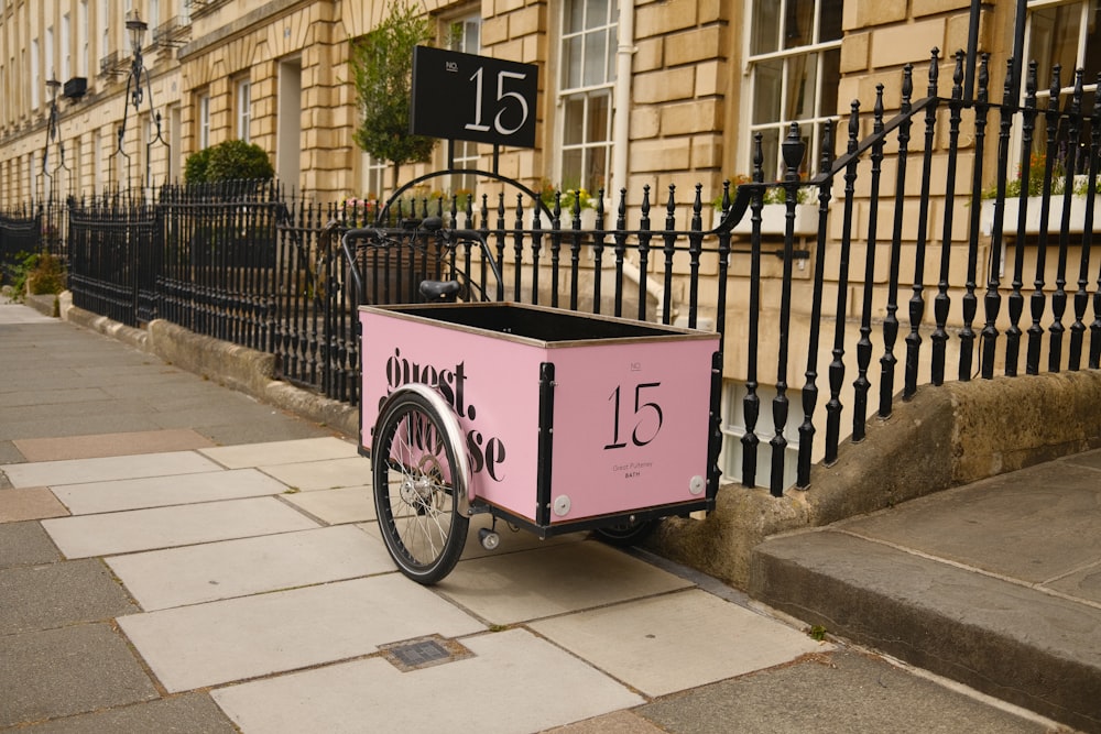 a pink bike parked on the side of a street