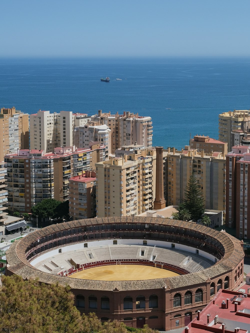 a view of a city with a large arena in the middle of it