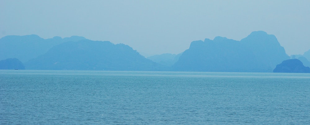 a large body of water with mountains in the background