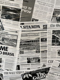 The image contains a collage of various international newspaper front pages, featuring headlines and images related to global news events. The papers have sections in different languages such as English, Italian, and Hebrew. Prominent topics include political issues and events, with accompanying black-and-white photographs.