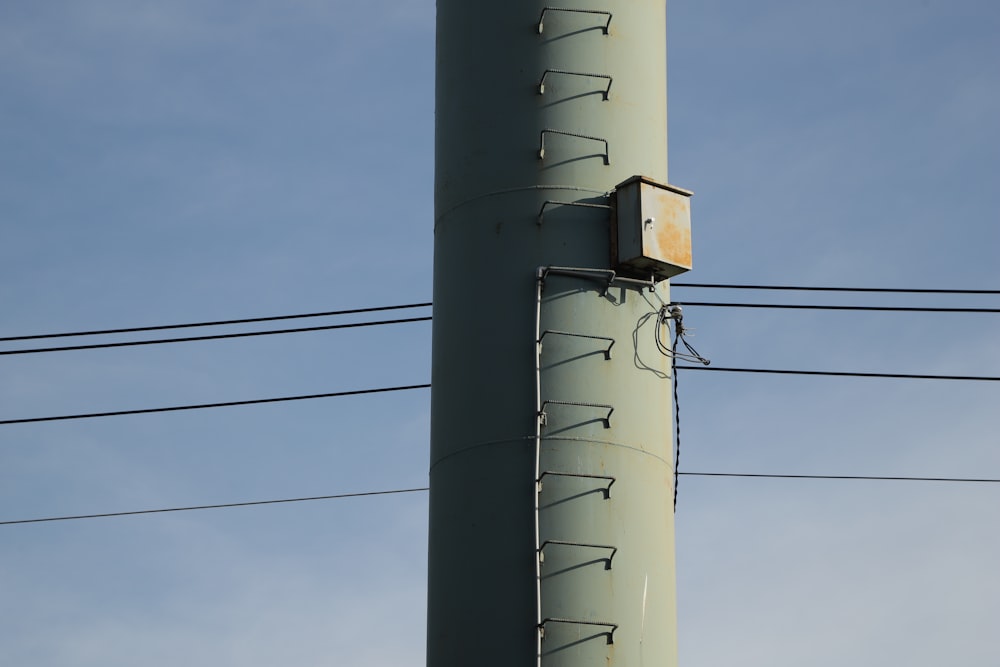 a telephone pole with a box attached to it