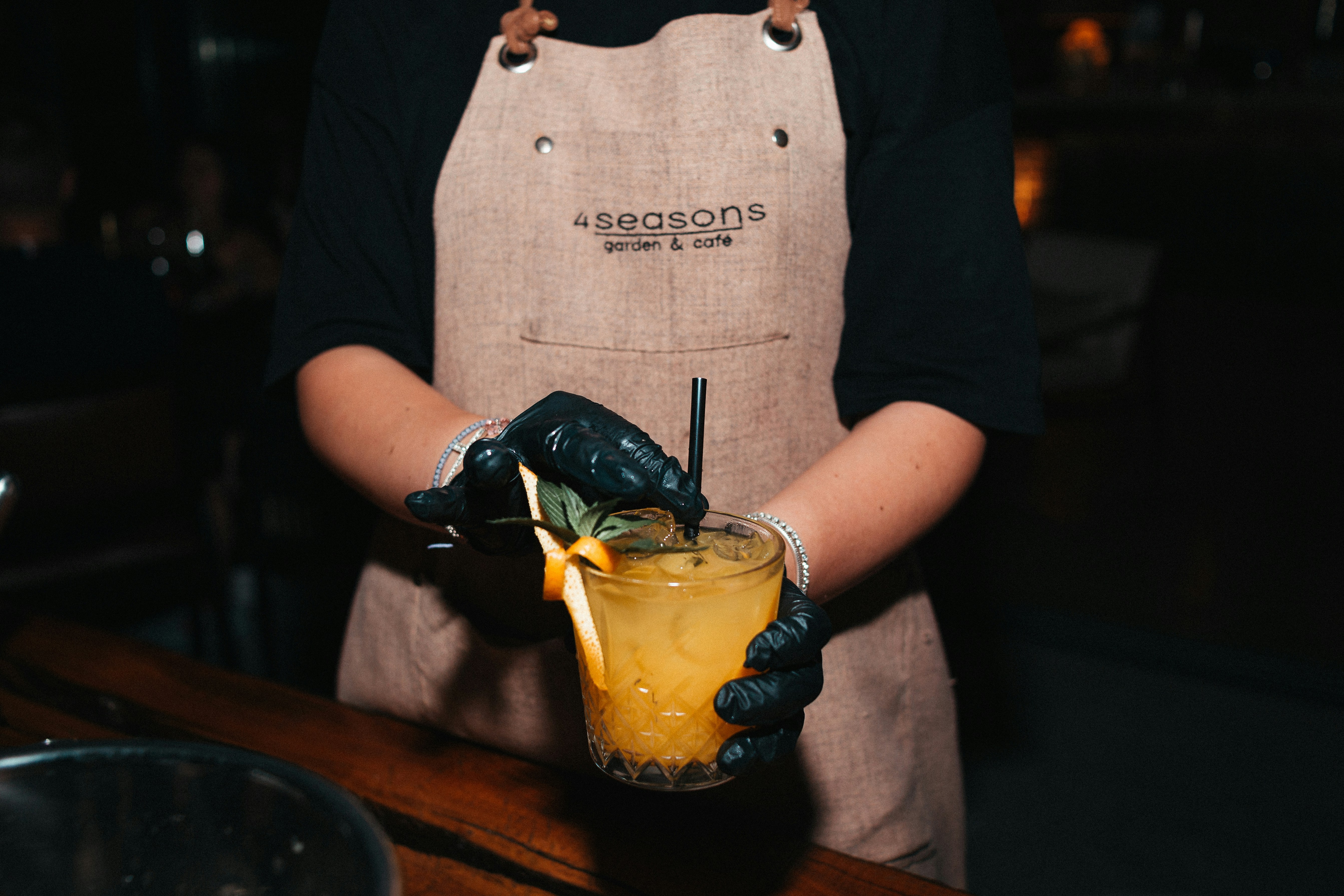 bartender wearing a stylish apron and holding a cocktail - bartender gifts