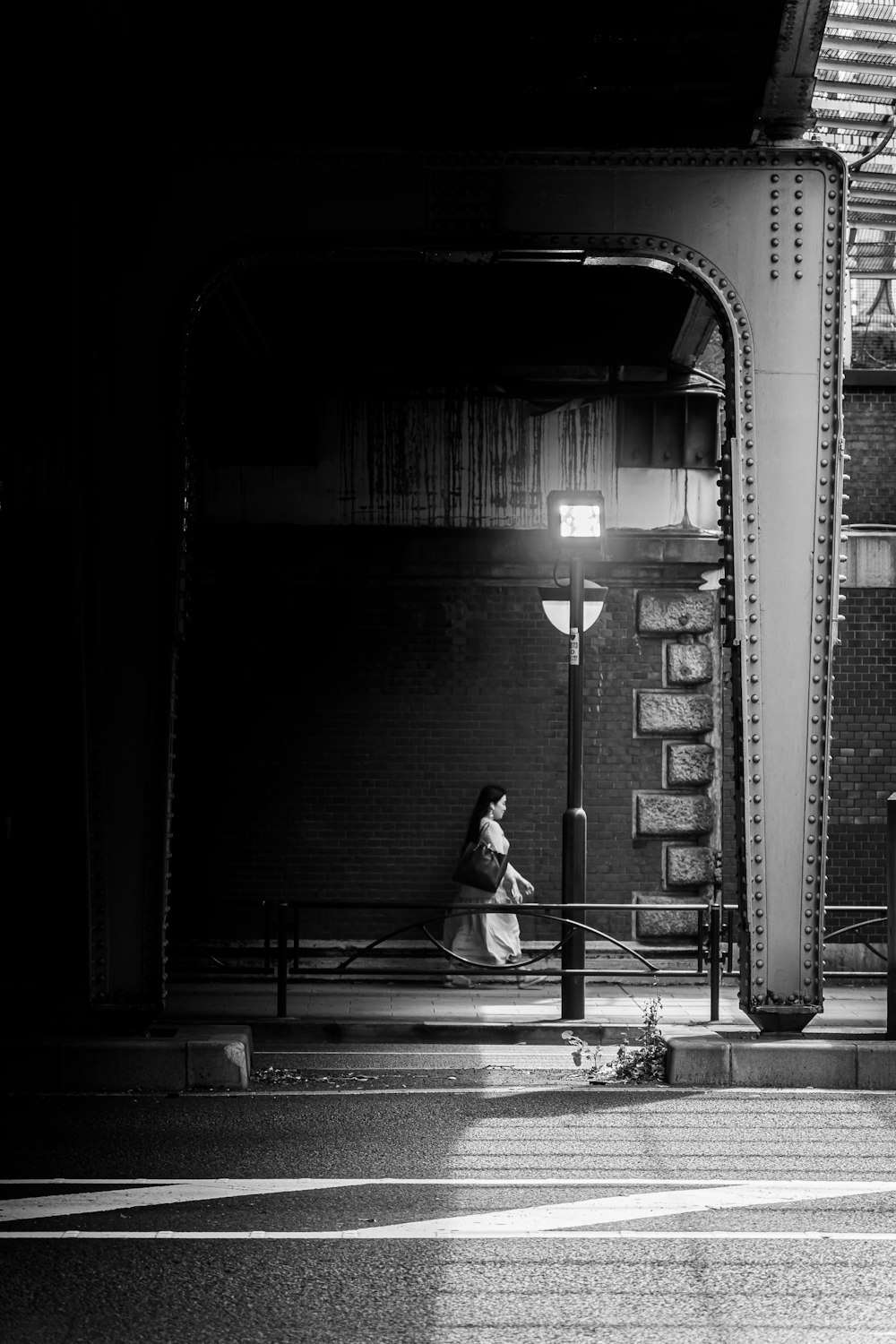 a black and white photo of a woman sitting on a bench