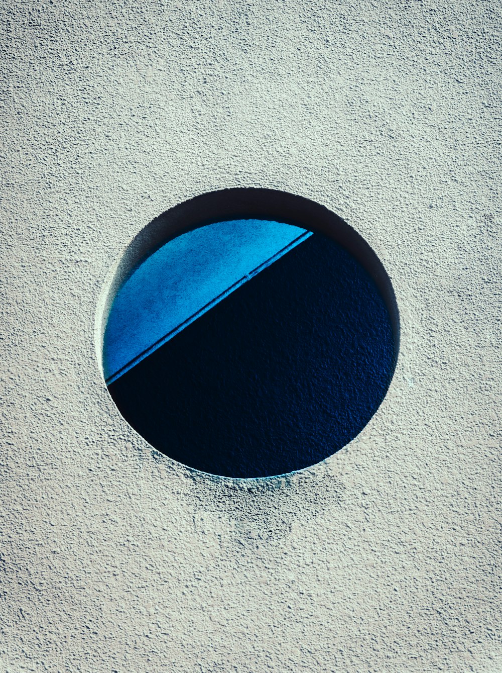 a round hole in the cement with a blue surface