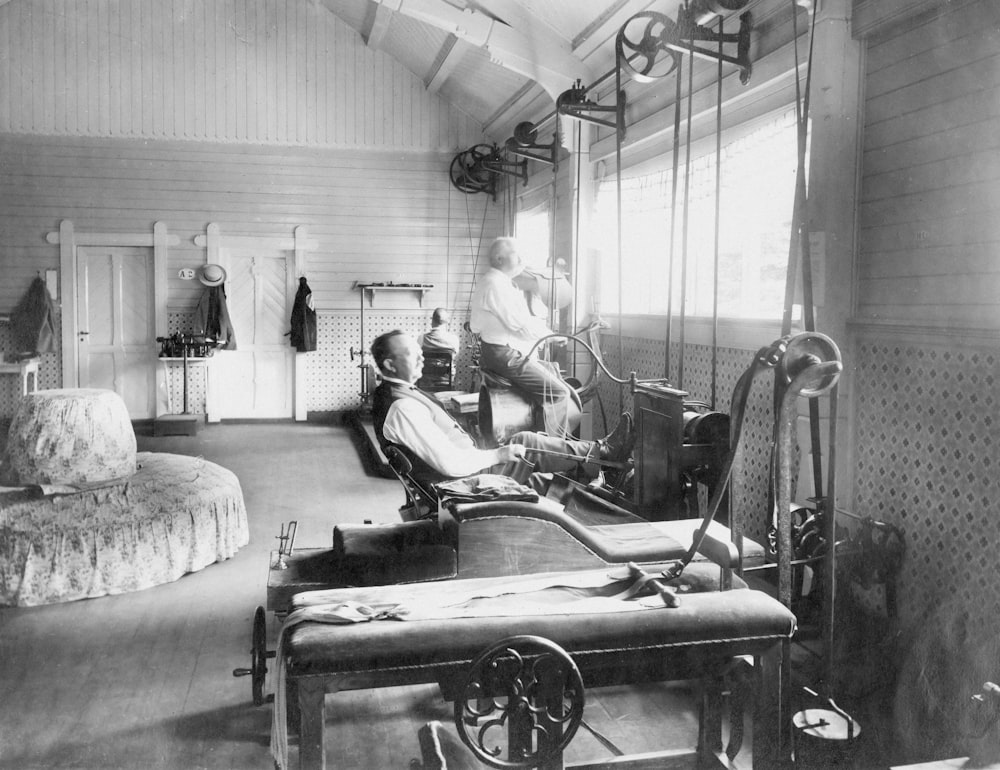 a black and white photo of a man working on a machine