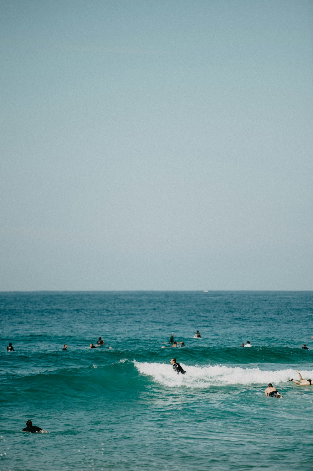 a group of people riding surfboards on top of a wave