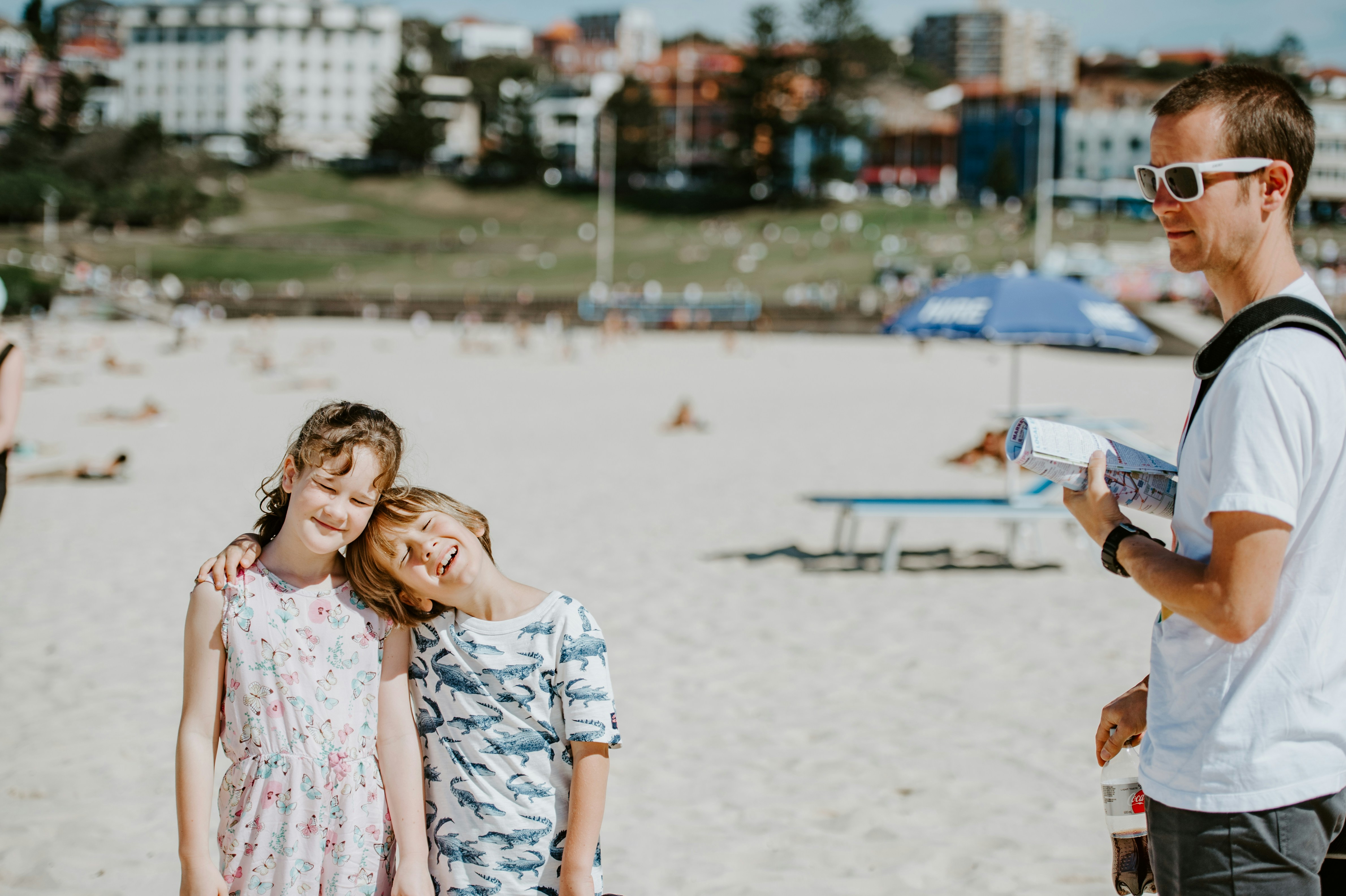 A man holding a map and children smiling on a beach.