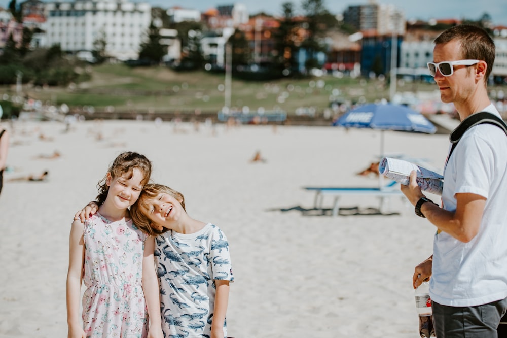 a group of people standing on top of a sandy beach