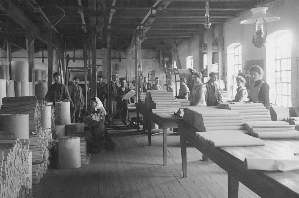 a black and white photo of people working in a factory